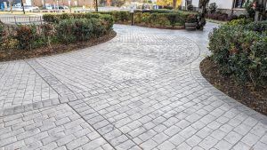 View of paths towards the parking lot of decorative concrete at Olde Mecklenburg Brewery in Charlotte, NC, using Bomanite Imprint Systems featuring the Running Bond Belgian Block pattern installed by Carolina Bomanite.